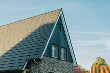 Nahaufnahme einer modernen niederländischen Hausfassade mit dunkler Thermory Vivid Thermo-Fichte Verkleidung und steilem Satteldach.