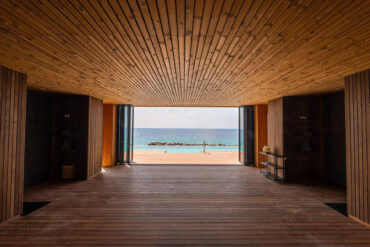 Thermory lämpömännystä tehty katto ja lämpösaarniterassi kehystävät merinäköalan Malediivien lomakeskuksessa.