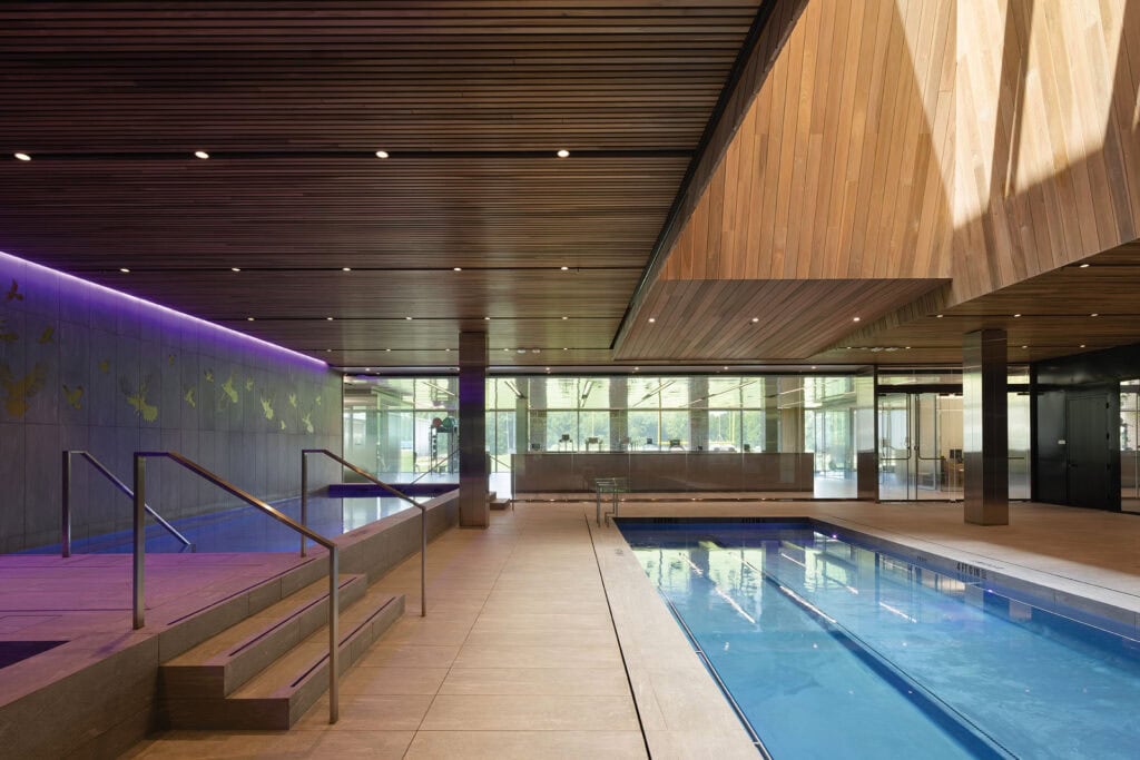 Hydrotherapy suite at the Baltimore Ravens’ Under Armour Performance Center featuring Thermory Thermo-Magnolia ceilings and wall panels with natural lighting.