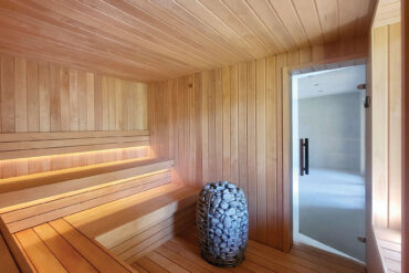 Thermory alder sauna interior with horizontal SHP bench boards and LED backlighting, minimalist design.