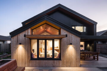 Rear façade of Cracoft Superhome showing Thermory Benchmark thermo-pine cladding, large windows and natural wood detailing.