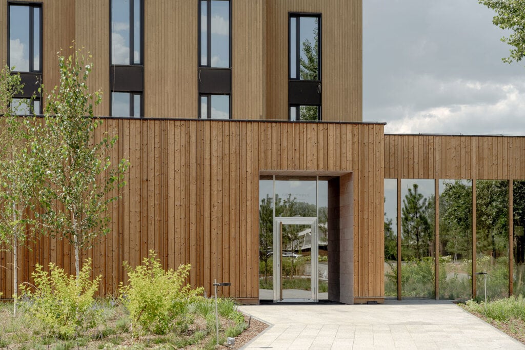 Exterior of Farm Table restaurant featuring Thermory thermo-spruce cladding and large windows surrounded by nature.