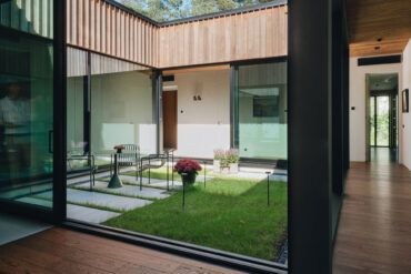 Sisäpiha lasiseinillä ja Thermoryn lämpösaarni-verhouksella, joka yhdistää sisä- ja ulkotilan.