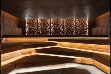 Les Bains de Lavey Sauna Tropical et Sel Marin astmeliste Thermory termoradiata männilavade ja taustvalgustusega voodrilaudadega.