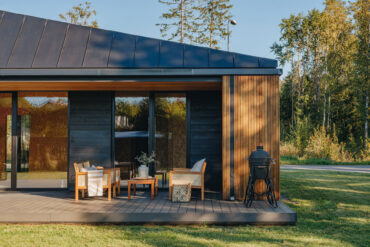 Outdoor terrace with Thermory thermo-hickory cladding and furniture in evening light.