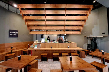 Front view of Ramen Taro restaurant with Thermory thermo-spruce benches, tables and ceiling beams, creating harmony between wood and light.