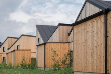 Row of modern houses in Sømmes Vænge clad in Thermory Benchmark thermo-pine C1, offering timeless warmth and sustainable architectural design.