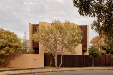 Stonningtonin asuintalon katujulkisivu Thermoryn lämpökäsitellyllä männyn pystyverhouksella ja pehmeän sävyisillä rappauspinnoilla.