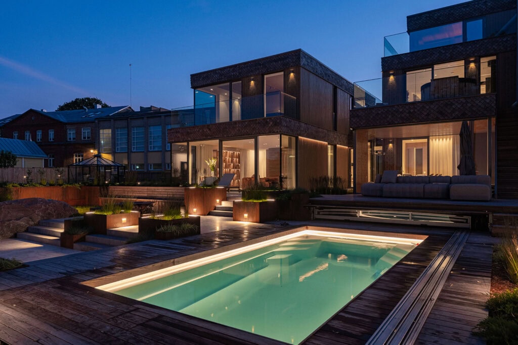 Evening view of Summer Villa with illuminated pool and Thermory thermo-ash decking in Haapsalu.