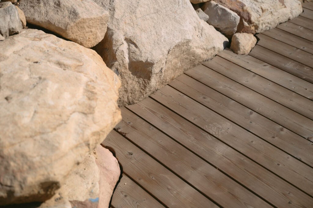 Thermory thermo-spruce decking beside natural sandstone rocks