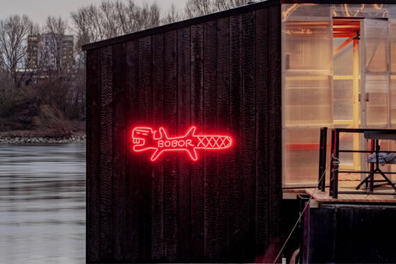 Sauna Bobor floating on the Danube River in Bratislava, clad in black shou sugi ban–treated Thermory thermo-spruce, blending craftsmanship with contemporary design