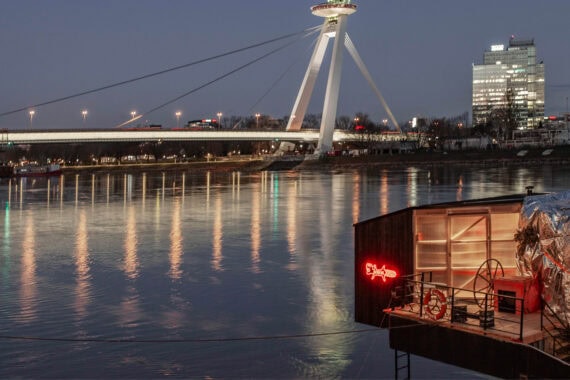 Sauna Bobor floating on the Danube River in Bratislava, clad in black shou sugi ban–treated Thermory thermo-spruce, blending craftsmanship with contemporary design